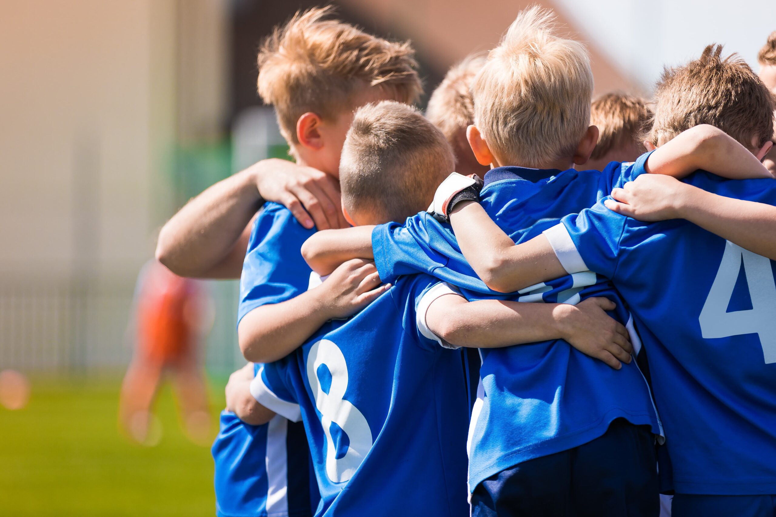 Boys gathered in a circle on the football field